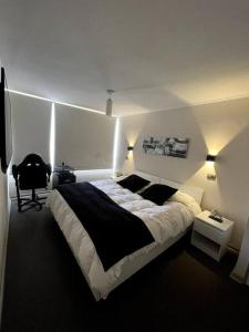 イキケにあるCondominio Playa Huantajayaのベッドルーム(ベッド1台、椅子、照明付)