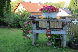 a garden gate with a pot of flowers on it at Zauberhaftes Gästehaus/Ferienwohnung Am Tiefenbach in Tiefenbach