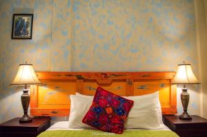 uma cama com dois candeeiros e uma almofada em Hostal Koltin Suchitoto em Suchitoto