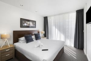 sypialnia z dużym białym łóżkiem i oknem w obiekcie Resort Family Two Bedroom 109 w mieście Torquay +6 zdjęć