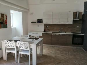 a kitchen with a white table and white chairs at Desy's house in Ferrandina