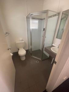 ein Bad mit einer Dusche, einem WC und einem Waschbecken in der Unterkunft Dalby Hotel Motel in Dalby