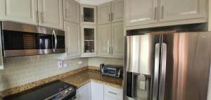 a kitchen with white cabinets and a stainless steel refrigerator at Infinity Townhomes at Bagatelle in Saint James