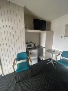 a room with two chairs and a table and a microwave at Dalby Hotel Motel in Dalby