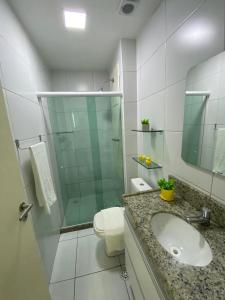 ein Badezimmer mit Toilette, Waschbecken und Dusche in der Unterkunft Muro Alto Condomínio Club in Porto De Galinhas