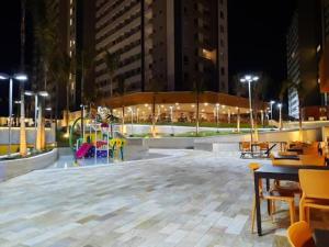 a large plaza with tables and chairs at night at Enjoy Solar das Aguas Park Resort in Olímpia