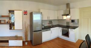 a kitchen with white cabinets and a stainless steel refrigerator at Ferienwohnung Haus Maier in Seeboden