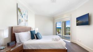 Un dormitorio con una cama y una ventana grande. en Unit 46 - 3 Bed Ocean View, en Terrigal