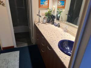 a bathroom counter with a blue sink and a mirror at Marina Lanais 609 in Fajardo
