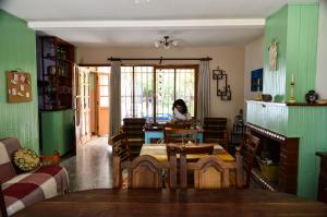 Hostel De La Tana في سان رافاييل: امرأة تجلس على طاولة في غرفة الطعام