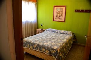 - une chambre avec un lit et un mur vert dans l'établissement Hostel De La Tana, à San Rafael