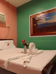 ein Schlafzimmer mit 2 Betten und einem Gemälde an der Wand in der Unterkunft WJV INN Canduman in Mandaue City