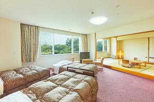 a hotel room with two beds and a television at KAMENOI HOTEL Fukui in Fukui