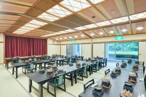 a large dining room with tables and chairs and windows at KAMENOI HOTEL Fukui in Fukui
