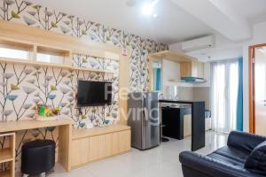 a living room with a tv on a wall at RedLiving Apartemen Star Semarang - Sky Tower Lantai 22 in Semarang