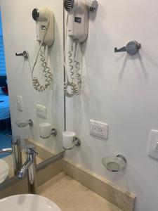 ein Badezimmer mit zwei Haartrocknern und einem Telefon an der Wand in der Unterkunft Seway Morros Cartagena in Cartagena de Indias