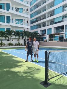 two men are standing on a tennis court at Seway Morros Cartagena in Cartagena de Indias