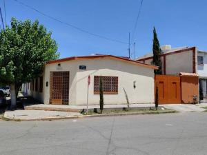 a white building with a red door on a street at Departamento moderno in Ciudad Juárez