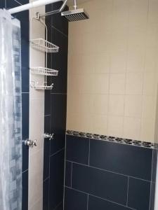 a bathroom with a shower with blue tiles at Departamento moderno in Ciudad Juárez