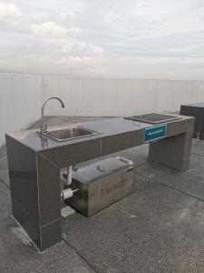 eine Küchentheke mit Spüle neben einer Wand in der Unterkunft Kajang Industrial House with Olympic Size Swimming Pool in Kajang