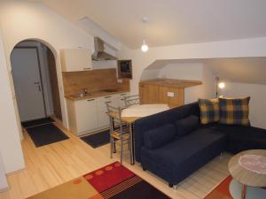 a living room with a blue couch and a kitchen at Salvesenheim in Tarrenz
