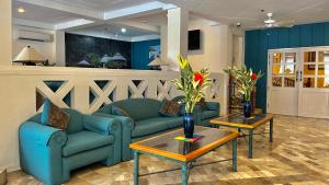 a living room with a blue couch and two tables at Coco Grande Hotel in Dumaguete