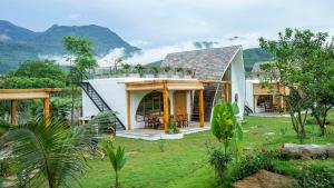 a house with a mountain in the background at Bavi Myan Maison in Yên Cư