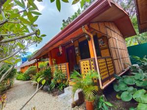 a house with a porch and plants in front of it at Adrianas Place in Panglao Island