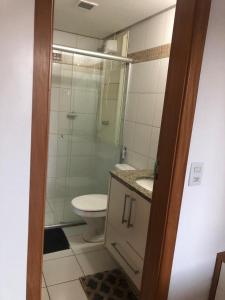 a bathroom with a toilet and a glass shower at Life Resort Flat - Torre F - Beira do lago in Brasilia