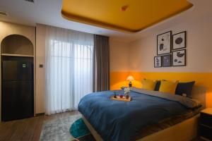 a bedroom with a large bed with a blue comforter at Pavillon Garden Hotel & Spa Nha Trang in Nha Trang