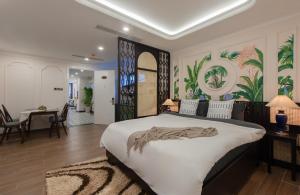 1 Schlafzimmer mit einem großen Bett und einem Esszimmer in der Unterkunft Pavillon Garden Hotel & Spa Nha Trang in Nha Trang