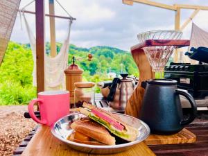 un sándwich en un plato en una mesa con una licuadora en 和心村ー古民家とグランピングと自然森山川海, en Minato