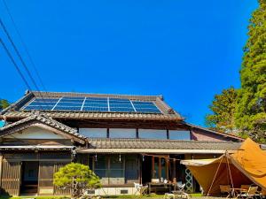 una casa con paneles solares en el techo en 和心村ー古民家とグランピングと自然森山川海, en Minato