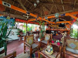 a restaurant with tables and chairs in a room at Adrianas Place Backpackers Hostel in Panglao Island