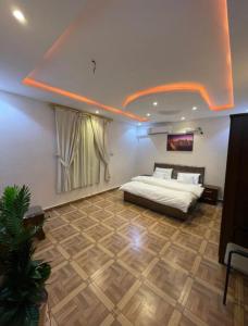 a bedroom with a bed and a ceiling with lights at شقق السودة هاوس in Suda