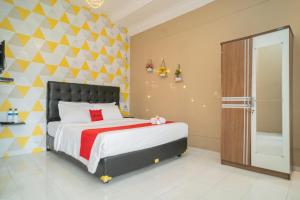 a bedroom with a bed and a geometric wall at RedDoorz near Taman Safari 2 in Bogor +21 photos