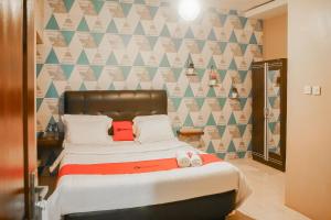 a bedroom with a bed and a geometric wall at RedDoorz near Taman Safari 2 in Bogor