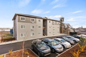 ein großes Apartmenthaus mit Autos auf einem Parkplatz in der Unterkunft Brand New 2 Bed 2 Bath Near Perry District and DT in Spokane