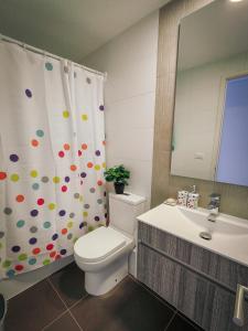 La salle de bains est pourvue de toilettes, d'un lavabo et d'un rideau de douche. dans l'établissement Cómodo departamento familiar a pasos de la playa, à Viña del Mar