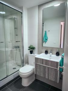 La salle de bains est pourvue de toilettes, d'un lavabo et d'une douche. dans l'établissement Cómodo departamento familiar a pasos de la playa, à Viña del Mar