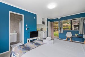 una camera con un grande letto con una parete blu di Westminster Mount View Unit 1 a Rotorua
