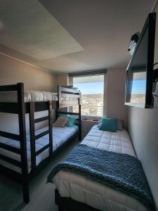 a bedroom with two bunk beds and a window at Cómodo departamento familiar a pasos de la playa in Viña del Mar