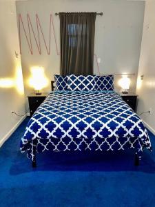 una camera con un letto blu e due lampade di 3 bedrooms 1 bath APT, 10 min to Manhattan! a Long Island City