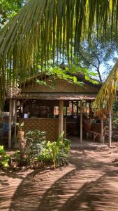 a building with a table and a palm tree at Pantai Paris Homestay in Maumere