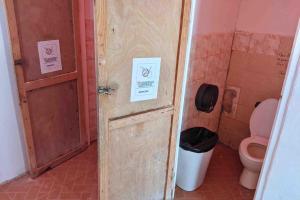 a small bathroom with a toilet and a door at Private Room in San Blas in Wagsalatupo Grande