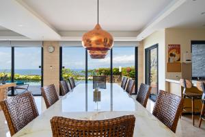 Un comedor con una mesa larga y sillas. en Moritz Palm Villa, en Uluwatu