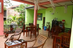 a restaurant with green walls and wooden tables and chairs at Little Heaven in Ella