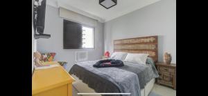 a bedroom with a bed and a chair and a desk at Lindo flat no Guarujá in Guarujá +50 photos