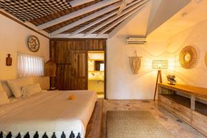 ein Schlafzimmer mit einem großen Bett und einem Schreibtisch in der Unterkunft Oma Villa - A tropical sanctuary of Seminyak in Seminyak