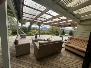 a patio with couches and a table on a deck at Luigi's home in Rotorua